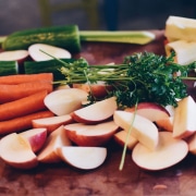 Bio-Lebensmittel: Geschnittene Äpfel, Karotten und Gurken auf einem Holzbrett